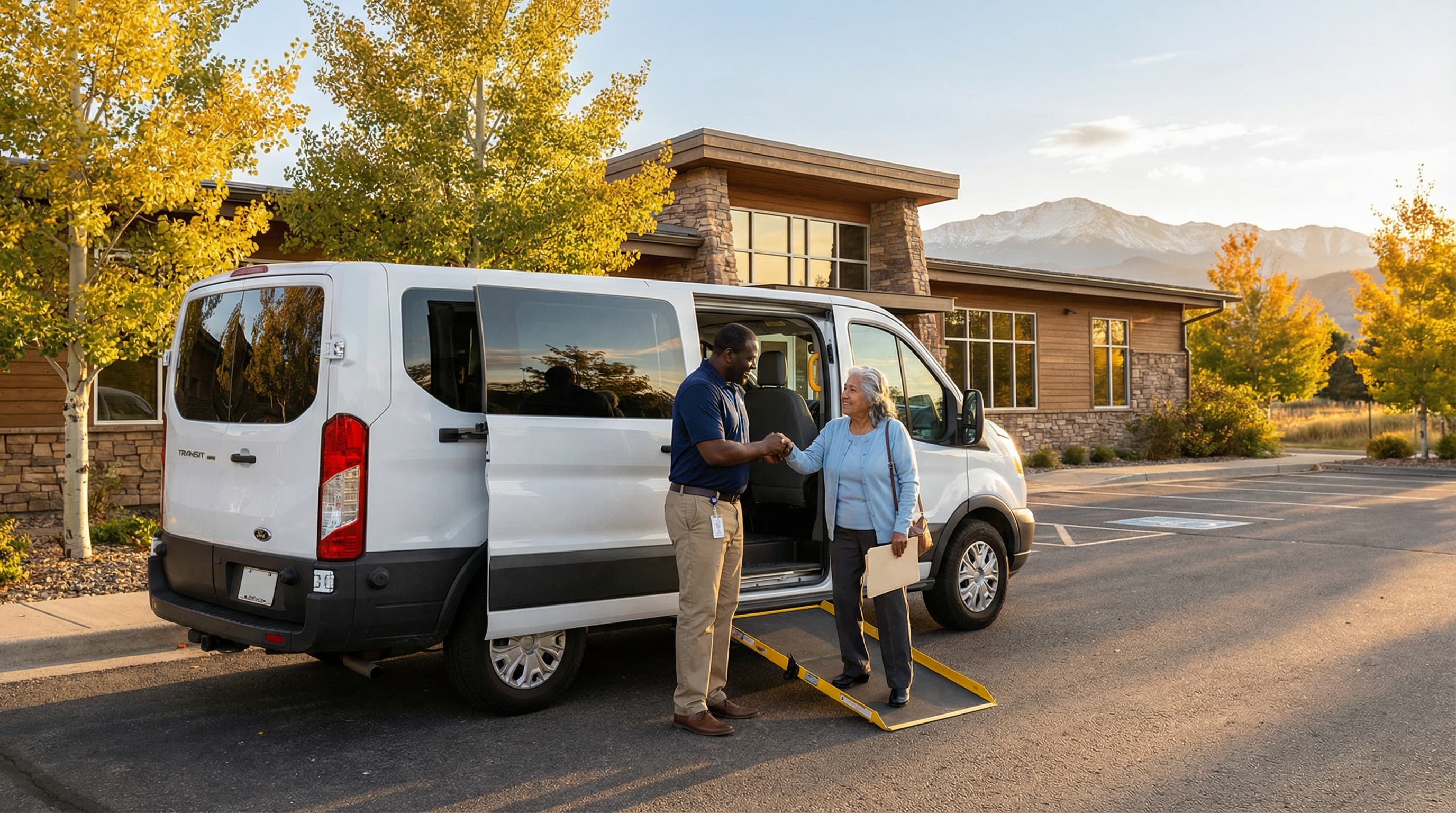 Driver assisting elderly passenger into medical transport van in Colorado