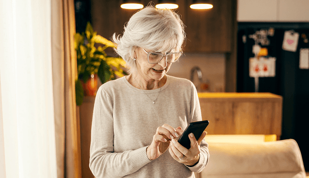 An older woman looking calling to schedule a medical ride.